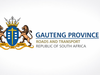 Cleaner in a government office corridor with a cleaning trolley, gloves, waste bins, and neatly maintained work areas.